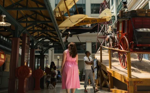 Visitors explore historic transportation displays inside the Smithsonian National Postal Museum.
